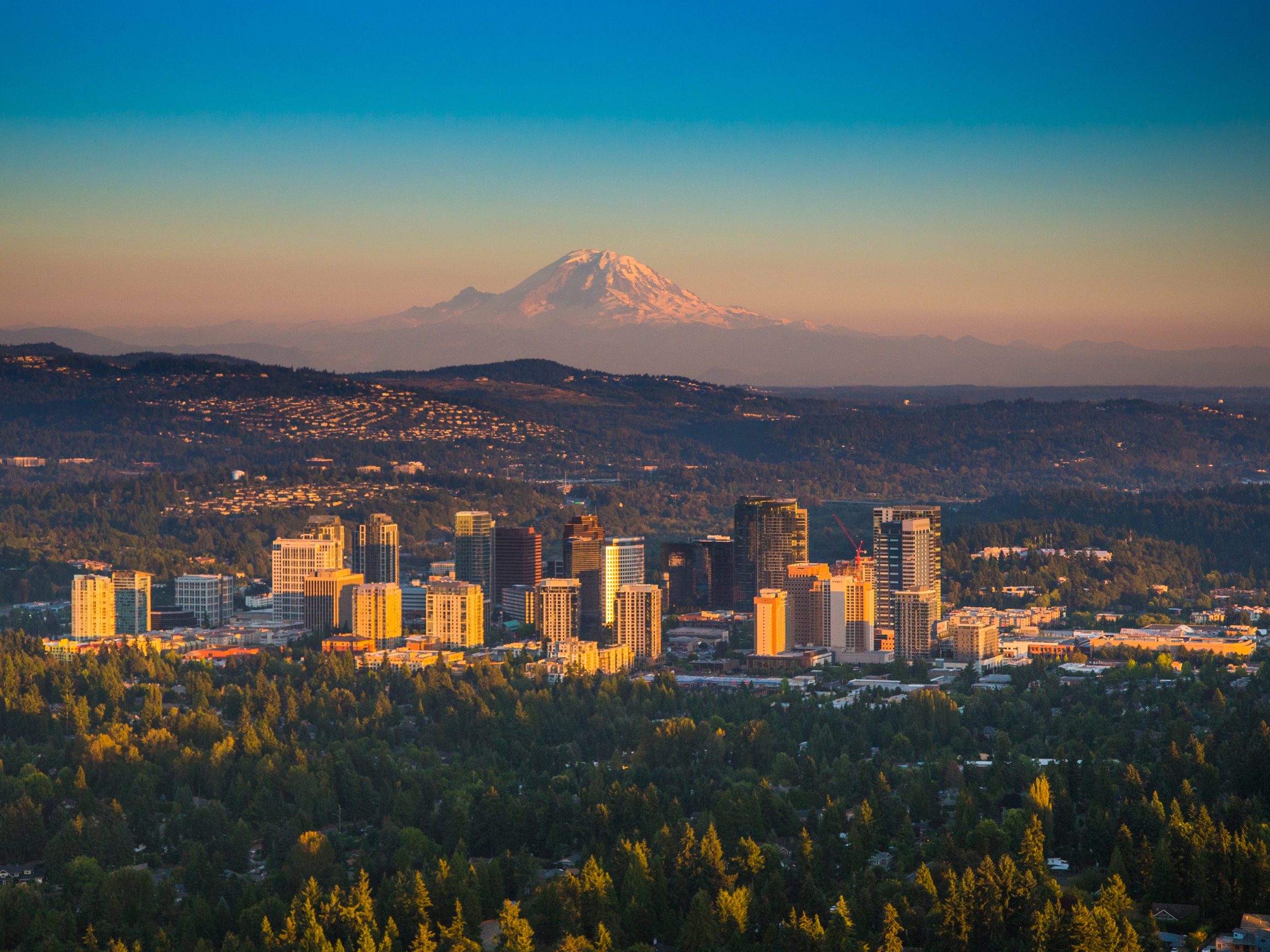 Downtown Bellevue skyline with Mount Rainier in the background at sunset.